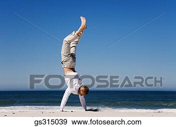 Stock Photograph - man doing handstand 
on beach. fotosearch 
- search stock 
photos, pictures, 
images, and photo 
clipart