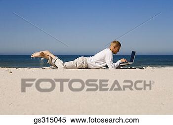 Stock Image - man lying down 
on beach with 
laptop. fotosearch 
- search stock 
photos, pictures, 
images, and photo 
clipart