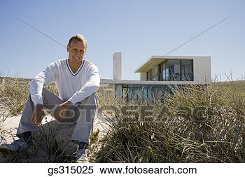 Stock Image - man sitting by 
beach house. fotosearch 
- search stock 
photos, pictures, 
images, and photo 
clipart