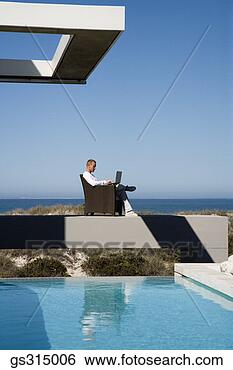 Stock Photo - man sitting by 
pool with laptop. 
fotosearch - search 
stock photos, 
pictures, images, 
and photo clipart
