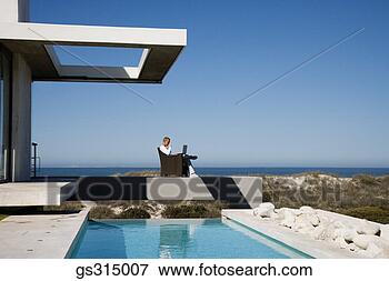 Picture - man sitting by 
pool with laptop. 
fotosearch - search 
stock photos, 
pictures, images, 
and photo clipart