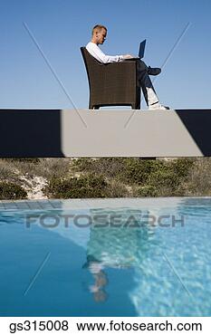 Stock Photo - man sitting by 
pool with laptop. 
fotosearch - search 
stock photos, 
pictures, images, 
and photo clipart