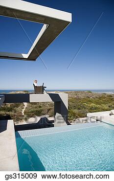 Stock Photograph - man sitting by 
pool with laptop. 
fotosearch - search 
stock photos, 
pictures, images, 
and photo clipart