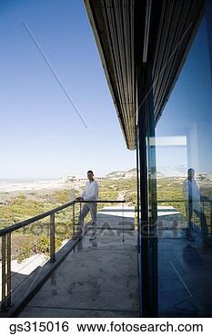 Stock Photo - man standing on 
balcony. fotosearch 
- search stock 
photos, pictures, 
images, and photo 
clipart