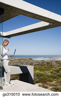 Stock Photography - man standing with 
laptop. fotosearch 
- search stock 
photos, pictures, 
images, and photo 
clipart