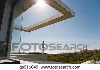 Stock Photograph - man standing on 
ledge over scenery. 
fotosearch - search 
stock photos, 
pictures, images, 
and photo clipart