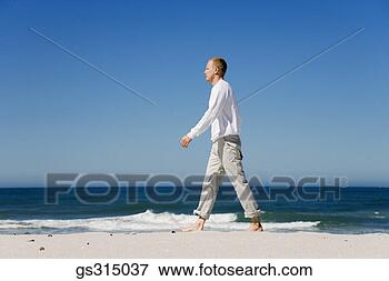 Picture - man walking on 
beach. fotosearch 
- search stock 
photos, pictures, 
images, and photo 
clipart