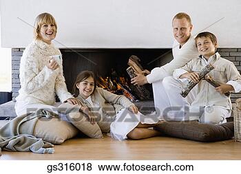 Stock Photo - family sitting 
by fireplace. 
fotosearch - search 
stock photos, 
pictures, images, 
and photo clipart