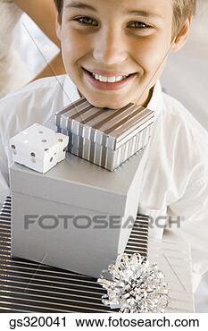 Stock Photography - boy smiling with 
stack of gifts. 
fotosearch - search 
stock photos, 
pictures, images, 
and photo clipart