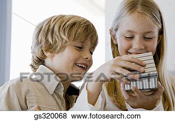 Stock Photo - children opening 
gift. fotosearch 
- search stock 
photos, pictures, 
images, and photo 
clipart