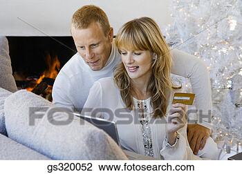 Stock Photo - couple shopping 
online by christmas 
tree. fotosearch 
- search stock 
photos, pictures, 
images, and photo 
clipart