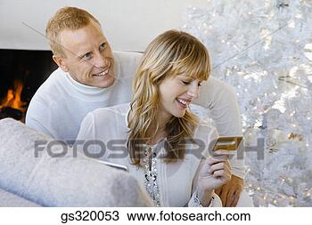 Stock Photo - couple shopping 
online by christmas 
tree. fotosearch 
- search stock 
photos, pictures, 
images, and photo 
clipart