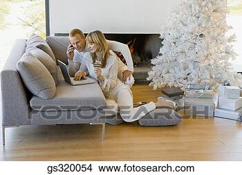 Stock Photo - couple shopping 
online by christmas 
tree. fotosearch 
- search stock 
photos, pictures, 
images, and photo 
clipart