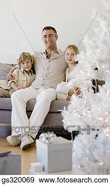Stock Photograph - family posing 
by christmas tree. 
fotosearch - search 
stock photos, 
pictures, images, 
and photo clipart