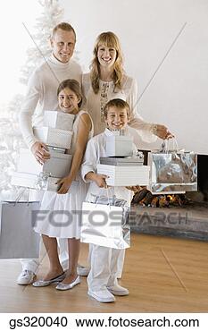 Stock Photography - family smiling 
with christmas 
gifts. fotosearch 
- search stock 
photos, pictures, 
images, and photo 
clipart