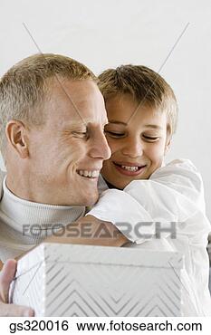 Stock Photo - father and son 
embracing with 
gift. fotosearch 
- search stock 
photos, pictures, 
images, and photo 
clipart