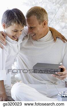 Stock Photo - father and son 
embracing with 
gift. fotosearch 
- search stock 
photos, pictures, 
images, and photo 
clipart