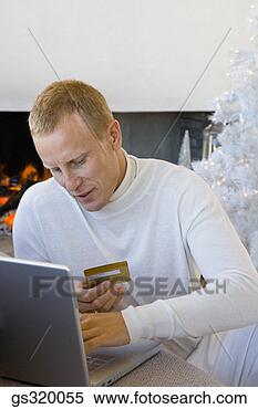 Stock Image - man shopping online 
with laptop and 
credit card. fotosearch 
- search stock 
photos, pictures, 
images, and photo 
clipart
