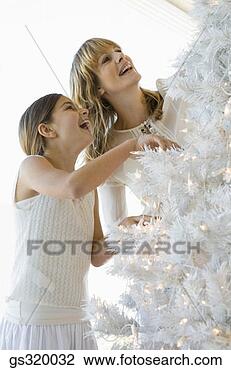 Stock Photo - mother and daughter 
decorating christmas 
tree. fotosearch 
- search stock 
photos, pictures, 
images, and photo 
clipart
