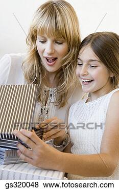 Stock Photo - mother and daughter 
opening gift. 
fotosearch - search 
stock photos, 
pictures, images, 
and photo clipart