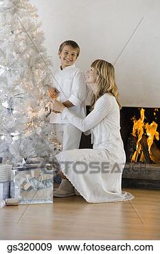 Stock Photograph - mother and son 
by christmas tree. 
fotosearch - search 
stock photos, 
pictures, images, 
and photo clipart