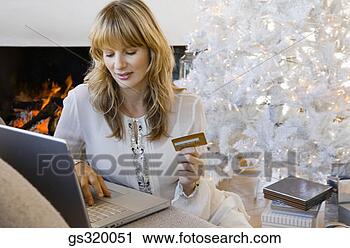 Stock Photography - woman using credit 
card and laptop 
by christmas tree. 
fotosearch - search 
stock photos, 
pictures, images, 
and photo clipart