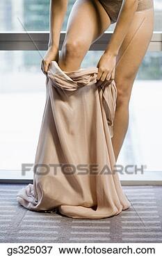 Picture - woman putting 
on dress. fotosearch 
- search stock 
photos, pictures, 
images, and photo 
clipart