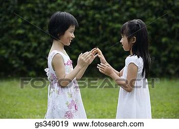 Stock Photograph - girls playing 
patty-cake outdoors. 
fotosearch - search 
stock photos, 
pictures, images, 
and photo clipart