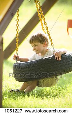 Picture - a two year old 
boy playing on 
a tire swing. 
fotosearch - search 
stock photos, 
pictures, images, 
and photo clipart