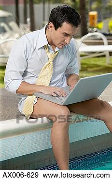 Stock Photograph - close-up of a 
mature man sitting 
on the ledge and 
using a laptop. 
fotosearch - search 
stock photos, 
pictures, images, 
and photo clipart