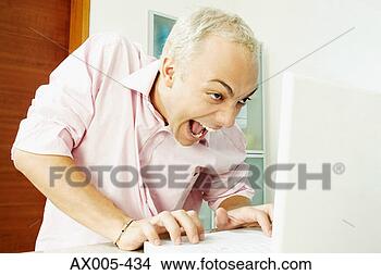 Stock Photo - close-up of a 
young man using 
a laptop and making 
a face. fotosearch 
- search stock 
photos, pictures, 
images, and photo 
clipart