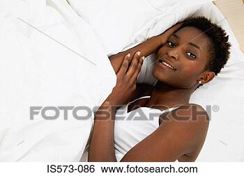 Stock Photo - woman resting 
in bed. fotosearch 
- search stock 
photos, pictures, 
images, and photo 
clipart
