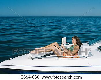 Stock Photography - woman on speedboat 
reading a book. 
fotosearch - search 
stock photos, 
pictures, images, 
and photo clipart