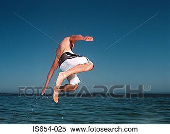 Stock Image - young man jumping 
into sea. fotosearch 
- search stock 
photos, pictures, 
images, and photo 
clipart