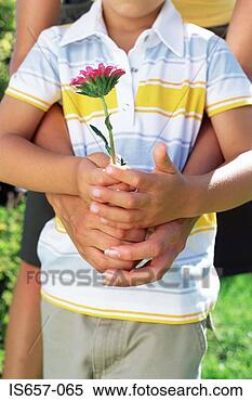 Stock Image - mother and son 
holding flower. 
fotosearch - search 
stock photos, 
pictures, images, 
and photo clipart