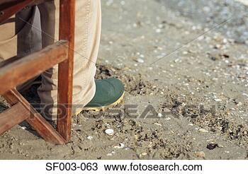 Stock Photo - person in rubber 
boots sitting 
in deck chair. 
fotosearch - search 
stock photos, 
pictures, images, 
and photo clipart