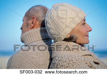 Stock Photo - senior couple 
back to back on 
beach. fotosearch 
- search stock 
photos, pictures, 
images, and photo 
clipart