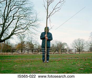 Stock Photo - man holding tree 
trunk in park. 
fotosearch - search 
stock photos, 
pictures, images, 
and photo clipart