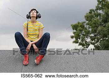 Stock Photo - young woman listening 
to music on roof. 
fotosearch - search 
stock photos, 
pictures, images, 
and photo clipart