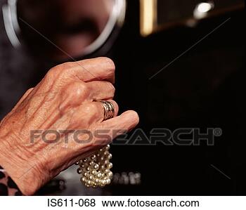 Stock Photo - senior woman holding 
pearl bracelet. 
fotosearch - search 
stock photos, 
pictures, images, 
and photo clipart
