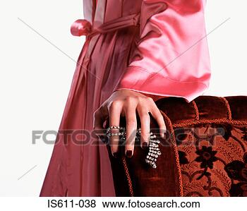 Stock Photo - woman holding 
necklace against 
chair. fotosearch 
- search stock 
photos, pictures, 
images, and photo 
clipart
