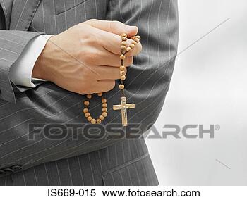 Stock Image - man holding rosary 
beads. fotosearch 
- search stock 
photos, pictures, 
images, and photo 
clipart