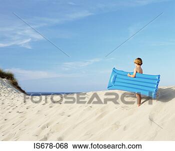 Stock Photo - boy with inflatable 
on edge of sand 
dune. fotosearch 
- search stock 
photos, pictures, 
images, and photo 
clipart