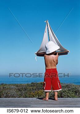 Stock Photo - boy holding a 
toy boat. fotosearch 
- search stock 
photos, pictures, 
images, and photo 
clipart