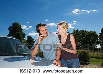 Stock Photography - couple by car 
using mobile phone. 
fotosearch - search 
stock photos, 
pictures, images, 
and photo clipart