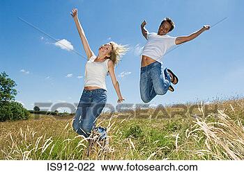 Stock Photo - couple jumping 
in a field. fotosearch 
- search stock 
photos, pictures, 
images, and photo 
clipart