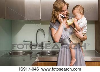 Stock Photo - woman holding 
baby whilst on 
mobile phone. 
fotosearch - search 
stock photos, 
pictures, images, 
and photo clipart