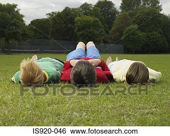 Stock Photo - children lying 
in the park. fotosearch 
- search stock 
photos, pictures, 
images, and photo 
clipart