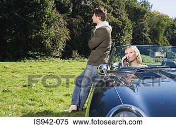 Stock Image - couple in field 
with convertible. 
fotosearch - search 
stock photos, 
pictures, images, 
and photo clipart