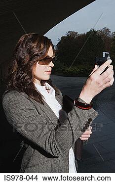 Stock Photo - woman using digital 
camera. fotosearch 
- search stock 
photos, pictures, 
images, and photo 
clipart